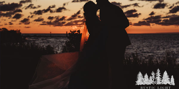 Silhouette photo of a bride and groom lakeside
